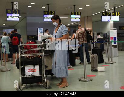 I viaggiatori sono in fila per effettuare il check-in dei bagagli presso lo sportello della British Airways dell'aeroporto internazionale di Ibiza, poiché l'industria del turismo in Spagna è stata duramente colpita dall'ultimo requisito di quarantena di 14 giorni da parte del governo britannico per tutti i turisti che viaggiano dalla Spagna a causa dei suoi alti livelli di casi COVID-19. Data foto: Sabato 1 agosto 2020. Foto Stock