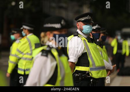 Gli ufficiali della polizia che indossano la copertura facciale durante una protesta della ribellione di estinzione a Parliament Square, Londra, il secondo giorno di dieci giorni di sconvolgimento in tutto il Regno Unito da parte del gruppo di attivisti del clima. Data foto: Mercoledì 2 settembre 2020. Foto Stock