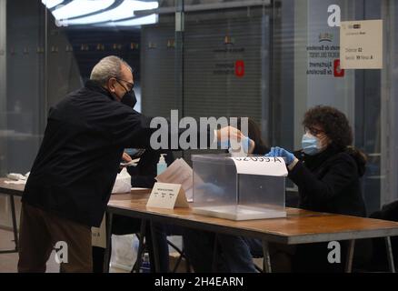 Un uomo lancia il suo voto al Mercat del Ninot, che è stato convertito in un seggio elettorale, a Barcellona durante le elezioni regionali in Catalogna, Spagna. Data immagine: 14 febbraio 2021. Il credito fotografico dovrebbe essere: Isabel Infantes Foto Stock