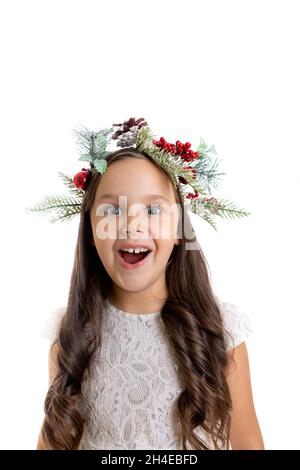 Primo piano ritratto di ragazza gioiosa ed eccitata con bocca aperta nella corona di Natale, abito bianco e ricci, isolato su sfondo bianco, sconti di Capodanno Foto Stock