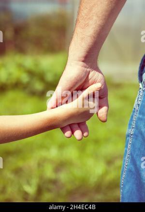 Padre e figlia mani sul background della natura Foto Stock