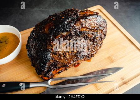 Spice strofinato osso-in permanente prima Rib Roast: Arrosto di manzo con salsa au jus prima di essere scolpito Foto Stock