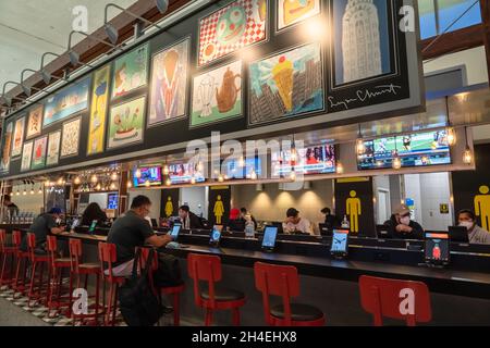 Bar confortevole con televisione e stazioni di ricarica presso il terminal dell'aeroporto di Los Angeles, California Foto Stock