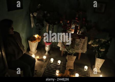 Una persona tiene una serata al cimitero di San Pedro Tláhuac, in attesa dell'arrivo dei loro cari defunti, i parenti decorano con fiori, Portate loro del cibo e cantate alle tombe come le tradizioni messicane di Day of the Dead per augurare loro un buon ritorno sulla strada per Mictlan. Il 1 novembre 2021 a Città del Messico, Messico. (Foto di Fernanda Rojas/ Eyepix Group) Foto Stock