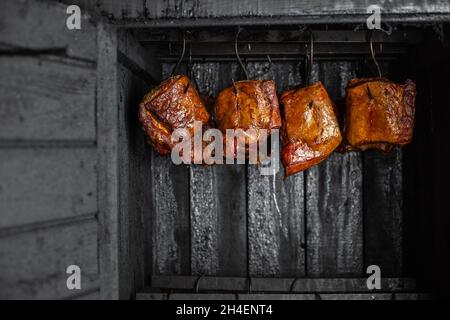 Fresco, delizioso affumicato, carne di maiale in affumicato, processo di affumicatura, concetto di cibo Foto Stock