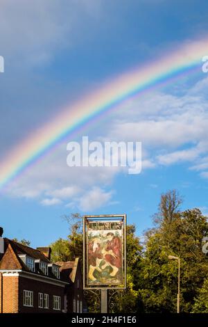 Arcobaleno pieno nel cielo sopra il segno del villaggio. High Street, Chalfont St Giles, Buckinghamshire, Inghilterra, Regno Unito, Regno Unito Foto Stock