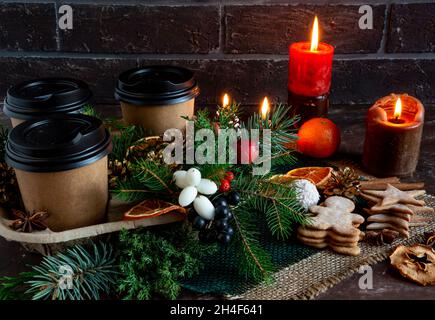 Composizione suggestiva di Natale e Capodanno su sfondo marrone, caffè, torta di Natale, rami di abete, coni, bacche, bastoncini di cannella, anis stellare Foto Stock