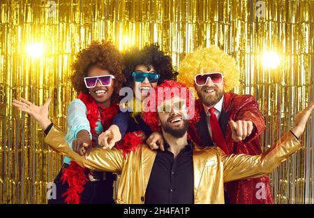 Ritratto di ridere persone in stile discoteca occhiali da sole, abiti  colorati su sfondo blu sfocato Foto stock - Alamy