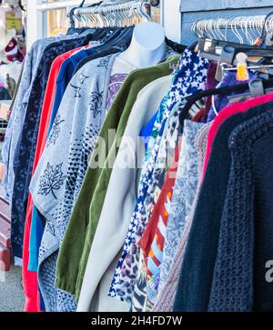 Vestiti appesi su una rotaia in un mercato di strada all'aperto. Vestiti colorati in vendita da un venditore di strada. Foto di strada, foto di viaggio, nessuno Foto Stock