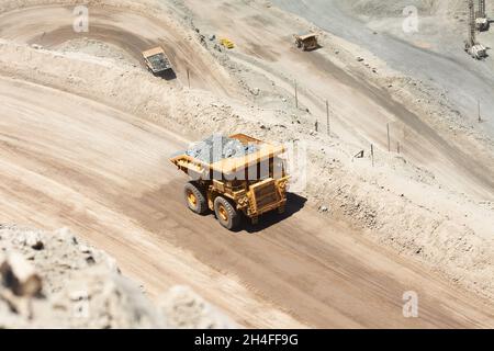 Enormi dumper caricati con minerali in una miniera di rame in Cile. Foto Stock