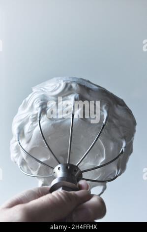 Montare gli albumi a neve in un picco su una frusta con palloncino Foto Stock