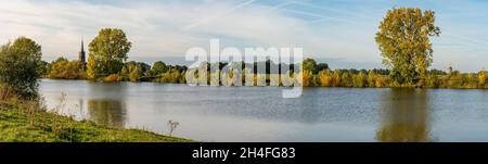 Vista panoramica della chiesa e mulino a vento di Batenburg lungo il fiume Mosa, provincia Gelderland, Paesi Bassi Foto Stock