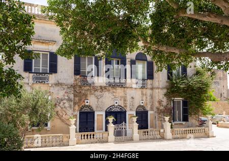 Casa pittoresca a Mdina, Malta, con porte blu navy e persiane, con modanature bianche innevate e cancello recinzione. Foto Stock