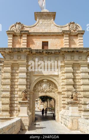 I turisti a piedi attraverso il portale barocco di Mdina Gate, noto anche come il portone o cancello Vilhena Foto Stock