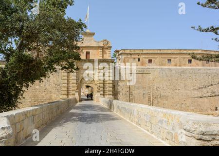 I turisti a piedi attraverso il portale barocco di Mdina Gate, noto anche come il portone o cancello Vilhena Foto Stock