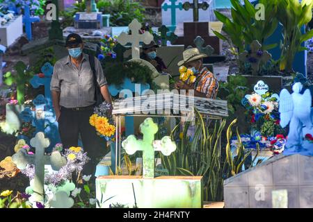 Suchitoto, El Salvador. 2 novembre 2021. Un uomo si trova accanto alla tomba di un parente in onore del giorno dei morti. La gente paga i loro rispetti e omaggi ai cari del cimitero di Suchitoto, ogni anno il 2 novembre, i Salvadorani commemorano il giorno dei morti per i loro parenti che passarono. Credit: SOPA Images Limited/Alamy Live News Foto Stock