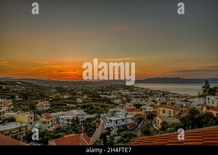 Tramonto su Platanias villaggio e baia da un alto punto di vista, Creta, Grecia, 10 ottobre 2021 Foto Stock