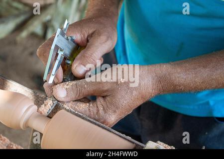 Mani anziane che girano legno Foto Stock