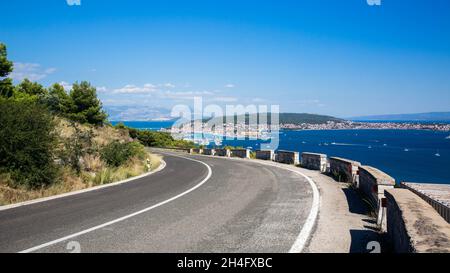 Vista della baia vicino Trogir in Croazia da una strada di montagna. Molti yacht si muovono sul mare in giornate di sole Foto Stock