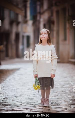 Adorabile bambina in abiti di tendenza nella città vecchia in primavera giorno di sole. Rovigno, Croazia Foto Stock