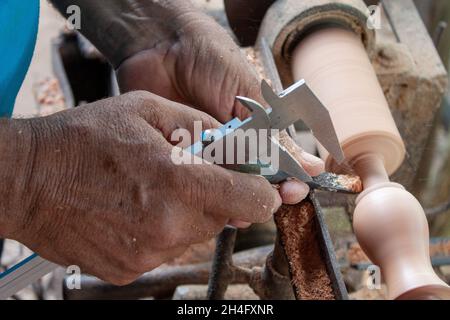 Mani anziane che girano legno Foto Stock