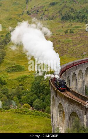 GLENFINNAN, SCOZIA - 3 SETTEMBRE 2021: Folle di persone si riuniscono per guardare il tradizionale treno a vapore Jacobite che attraversa il famoso viadotto a Glenfinn Foto Stock