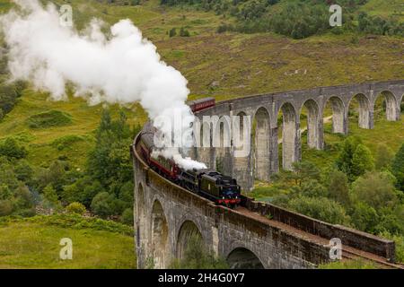 GLENFINNAN, SCOZIA - 3 SETTEMBRE 2021: Folle di persone si riuniscono per guardare il tradizionale treno a vapore Jacobite che attraversa il famoso viadotto a Glenfinn Foto Stock