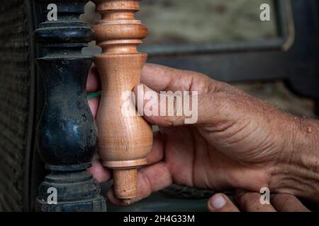 Mani anziane che girano legno Foto Stock