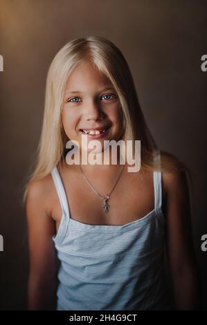 Ritratto di una bella ragazza bionda nel suo appartamento. Con capelli lunghi e sciolti sorridenti. Foto Stock