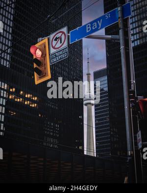 Cartello 'Bay St' al semaforo con vista della torre CN dietro gli alti edifici di Toronto Foto Stock