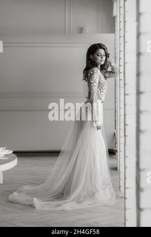 Una sposa di lusso in un abito da sposa al mattino nel suo interior.foto in bianco e nero. Foto Stock