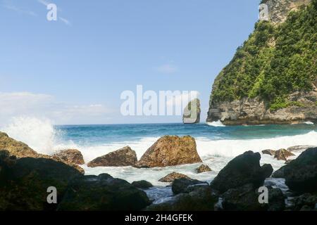 Ritratto di onde che colpiscono rocce rotonde e schizzi Foto Stock