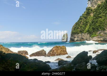 Ritratto di onde che colpiscono rocce rotonde e schizzi Foto Stock