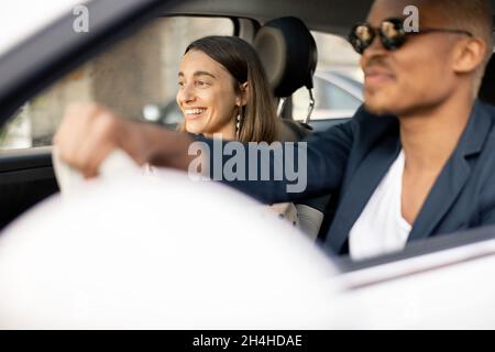 Felice coppia multirazziale che guida insieme in auto Foto Stock