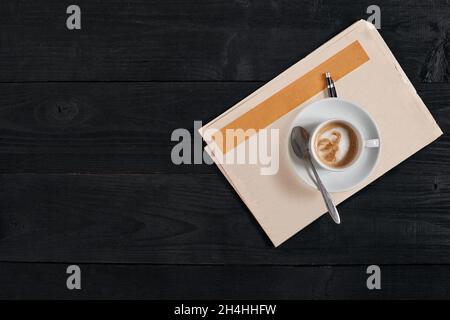 Spazio di lavoro con quotidiano e tazza di caffè. Elegante scrivania da ufficio. Concetto di autunno o inverno. Disposizione piatta, vista dall'alto Foto Stock