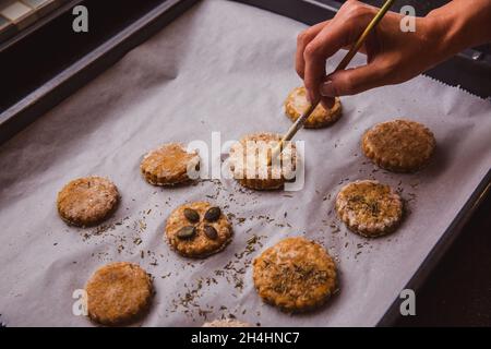 Donna scone vetrata con spazzola pronta per andare in forno. Primo piano Foto Stock