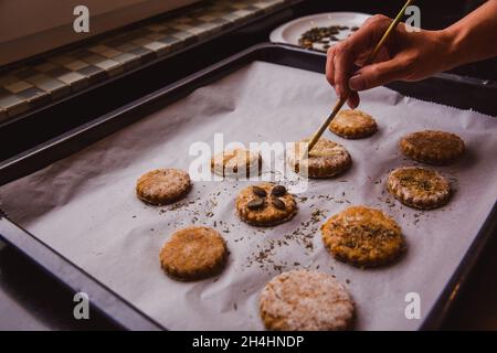 Donna scone vetrata con spazzola pronta per andare in forno. Primo piano Foto Stock