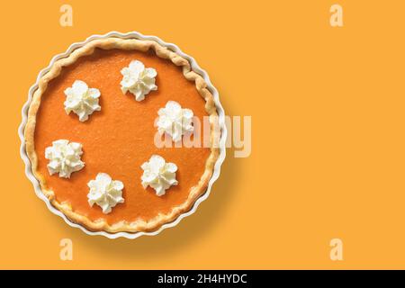 Torta di zucca tradizionale americana fatta in casa con spezie, cannella, cardamomo, zenzero per il giorno del Ringraziamento su sfondo arancione. Vista dall'alto. Copia spa Foto Stock