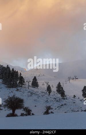 Inverno tranquillo paesaggio nuvoloso di montagna al tramonto. Splendida vista sulle montagne innevate con splendidi abeti sul pendio Foto Stock