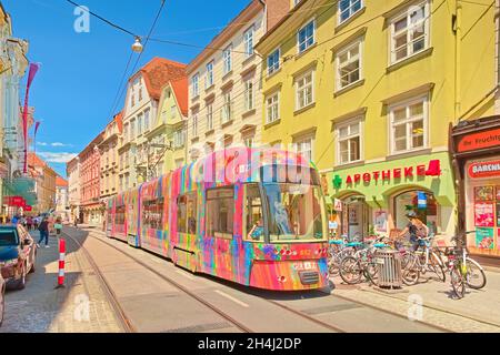 Graz - 2020 giugno, Austria: Un tram moderno con pubblicità colorate sta percorrendo una delle strade centrali di Graz Foto Stock