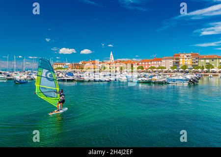 Izola - 2020 giugno, Slovenia: Una donna windsurf nel porto di Izola Foto Stock