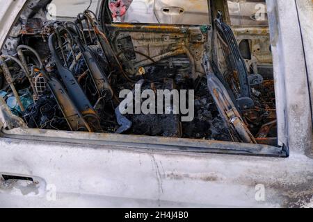 rottura del relitto interno dell'auto. Posti auto bruciati in strada. Sommossa, protesta civile, hooliganismo in città. Esplosione, incendio. Incidente stradale. Assicurazione. Foto Stock