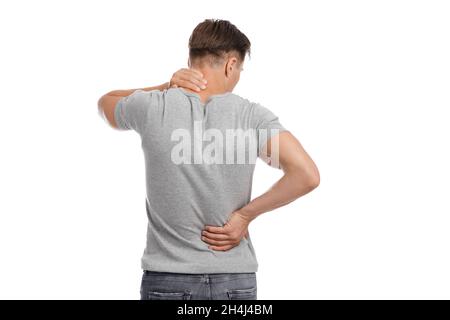 Stanco giovane maschio caucasico massaggiando macchie di dolore e soffrendo di mal di schiena e di collo Foto Stock