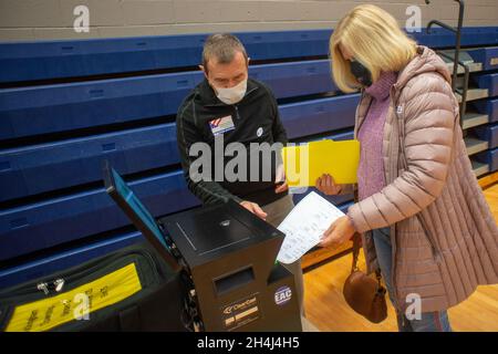 Buckingham, Stati Uniti. 2 novembre 2021. Lisa Meinert (a destra), di Buckingham scansiona il suo scrutinio come lavoratore di sondaggio Will Faussett assiste al luogo di votazione Martedì, 02 novembre 2021 alla Central Bucks East High School di Buckingham, Pennsylvania. ( Credit: William Thomas Cain/Alamy Live News Foto Stock