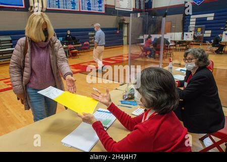 Buckingham, Stati Uniti. 2 novembre 2021. Da sinistra, Lisa Meinert, di Buckingham è consegnato un voto forma da Nancy Faussett al luogo di votazione Martedì, 02 novembre 2021 alla Central Bucks East High School di Buckingham, Pennsylvania. ( Credit: William Thomas Cain/Alamy Live News Foto Stock