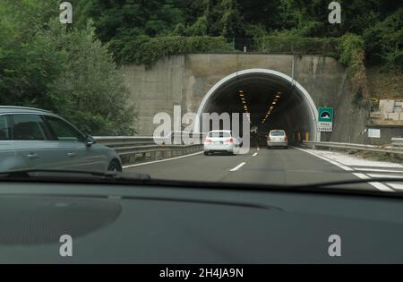 Tunnel sotterraneo in città con auto in auto. Infrastrutture urbane. Autostrada attraverso le montagne di fronte. Trasporto, viaggi Foto Stock