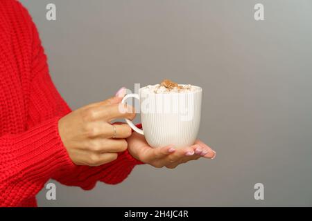 Gustatevi cioccolata calda o cacao con marshmallows: Tazza da presa femminile con bevanda calda invernale o autunnale Foto Stock