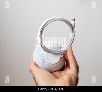Uomo che sboxe l'ultimo Apple Computers HomePod Mini altoparlante intelligente Foto Stock