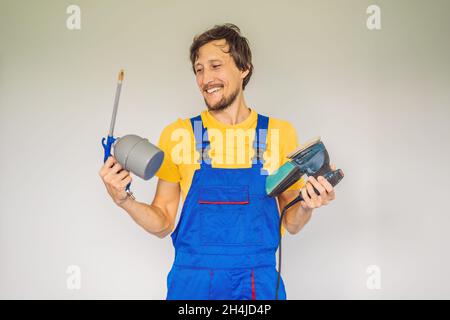 Pittore in abiti da lavoro con una pistola a spruzzo di vernice Foto Stock