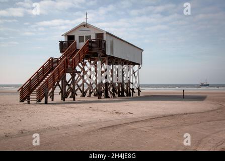 Edifici su palafitte e nave sulla spiaggia del Mare del Nord a von St Peter Ording Germania Foto Stock